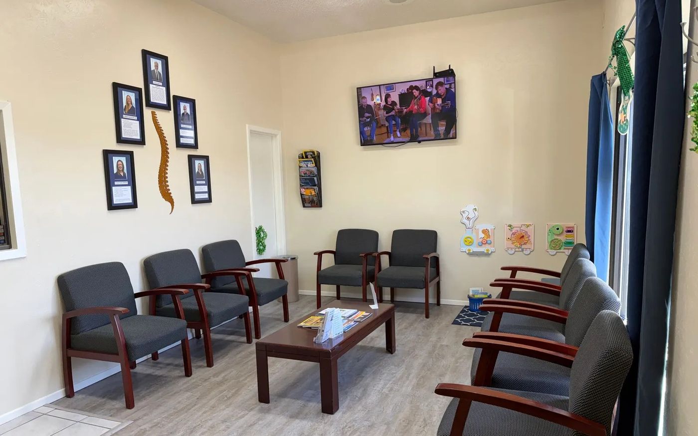 The waiting room inside Denton Chiropractic Center, with the doctors' photos on the wall